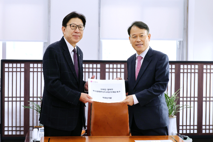 박형준 부산시장이 윤한홍 국회 정무위원장에게 건의문을 전달하고 있다. 부산시 제공