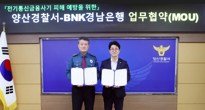 BNK경남은행 조필호 금융센터장(사진 오른쪽)과 양산경찰서 김종규 서장이 '전기통신 금융사기 피해 예방을 위한 업무 협약'을 체결하고 있다. BNK경남은행 제공 