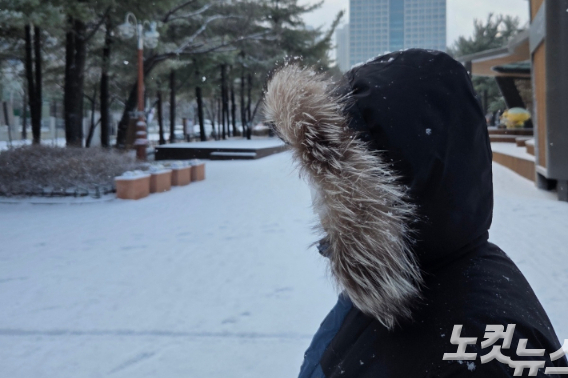 대설이 내린 24일 대전 서구 둔산동에서 한 시민이 두꺼운 점퍼와 모자를 쓴 채 걷고 있다. 박우경 기자