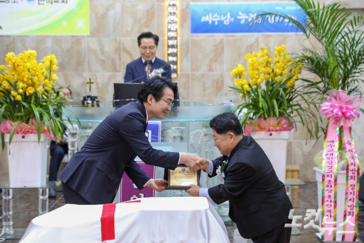직전 회장 오경수 목사가 총회장 명의의 공로패를 전달받고 있다. 최화랑 기자