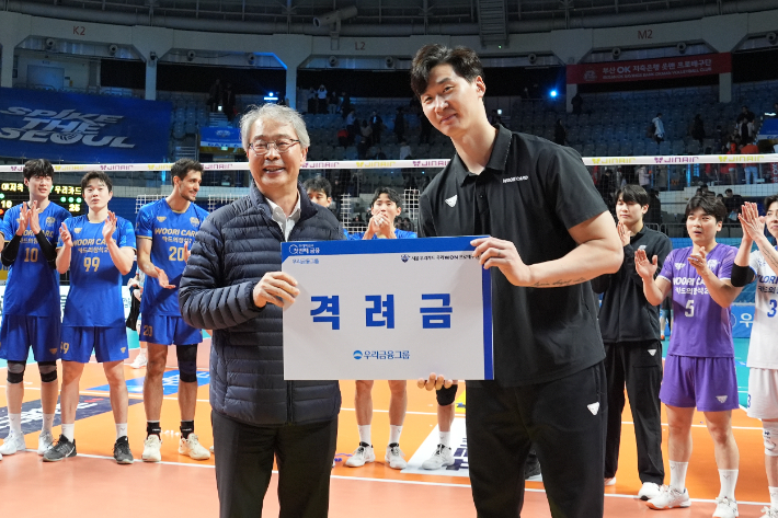 우리금융그룹 임종룡 회장(왼쪽)이 25일 5연승을 달린 우리카드 박철우 감독 대행에게 격려금을 전달한 뒤 기념 촬영하고 있다. 우리카드 