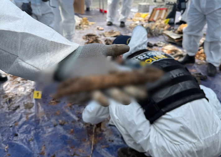 26일 오전 무안국제공항에서 진행된 사고기 잔해물 보관 개선 작업 중 사람의 뼈로 추정되는 시신 일부분이 발견됐다. 유가족협의회 제공