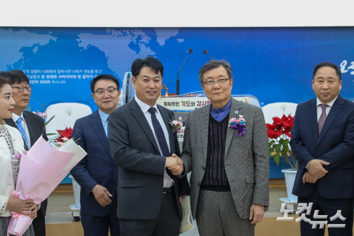 군산시기독교연합회 제34회기 정기총회에서 신임 대표회장으로 선출된 이천우 목사(오른쪽)와 이임하는 임홍길 목사가 악수하고 있다. 최화랑 기자