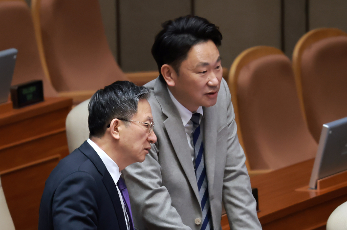 더불어민주당 곽상언 의원과 정성호 법무부 장관이 25일 국회에서 열린 2월 임시국회 본회의에서 대화하고 있다. 연합뉴스