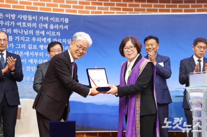 조정애 신임 노회장이 이종덕 직전 노회장에게 공로패를 전달하고 있다. 최화랑 기자