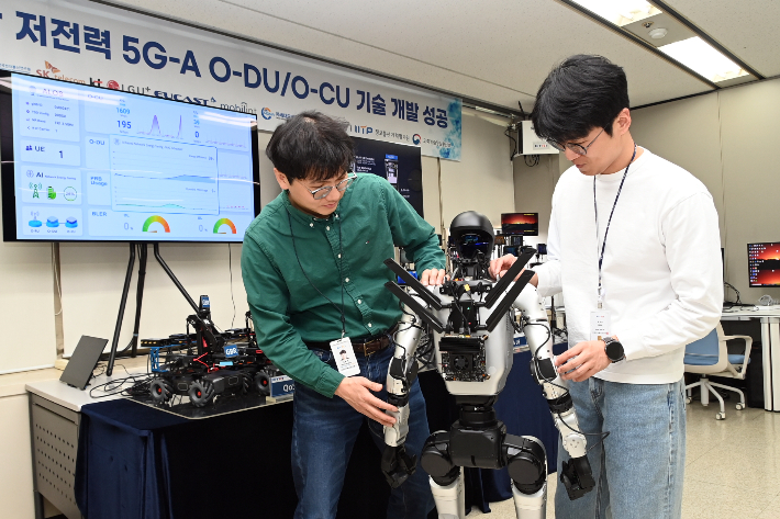 ETRI 연구진이 5G모뎀을 설치한 로봇과 오픈랜 저전력 기지국과 연결하고 있다. ETRI 제공