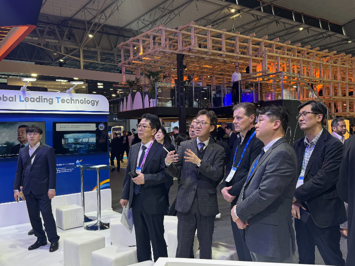 스페인 바르셀로나에서 열린 MWC 2026에서 한국수자원공사 관계자가 K-water관을 찾은 외국인 방문객에게 물관리 디지털트윈 등 AI 기반 최첨단 물관리 기술을 설명하고 있다. 수자원공사 제공