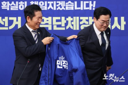 4일 서울 여의도 국회에서 열린 더불어민주당 공천심사 결과 발표에서 정청래 대표가 인천광역시장 후보로 단수 공천된 박찬대 의원에게 당 선거복을 전달하고 있다.