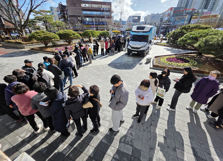 지난 3일 광주 북구청 광장에 설치된 '부끄머니 발급 출장버스' 앞으로 순서를 기다리는 주민들이 줄을 서 있다. 광주 북구 제공