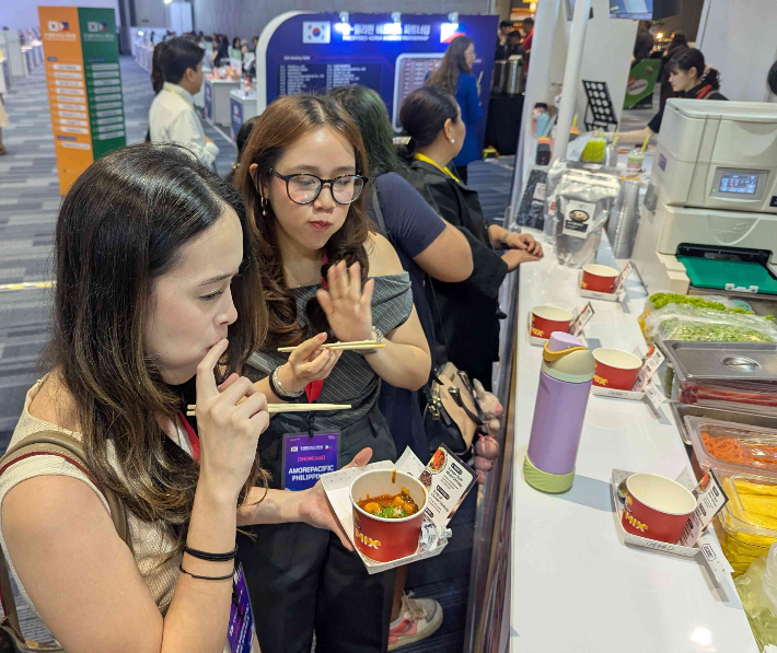 코트라가 4일 필리핀 마닐라에서 '한-필리핀 비즈니스 파트너십'을 개최했다. 현장에서는 K-프랜차이즈 시식회가 동시에 진행됐다. 필리핀 바이어가 김밥과 떡볶이를 맛보고 있다. 코트라 제공