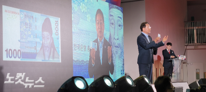 4일 유정복 인천시장이 자신의 출판기념회에서 천 원짜리 지폐를 꺼내들고 주요 정책 성과를 설명하고 있다. 박창주 기자 