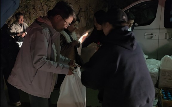 4일(현지시간) 새벽 1시간 조금 넘은 시각 이집트 수도 카이로의 외국인 밀집 거주 지역인 마디의 빅토리아 광장 인근에 전쟁의 포화를 피해 국경을 넘은 이스라엘 체류 국민과 동포, 단체관광객 등이 도착해 주이집트한국대사관이 마련한 도시락을 받아 들고 있다. 연합뉴스