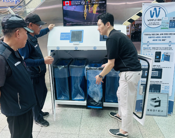 공단 관계자가 재활용 쓰레기 자동 분류 혁신 기술이 적용된 'IoT 스마트 리사이클링 시스템'을 살펴보고 있다. 부산시설공단 제공 