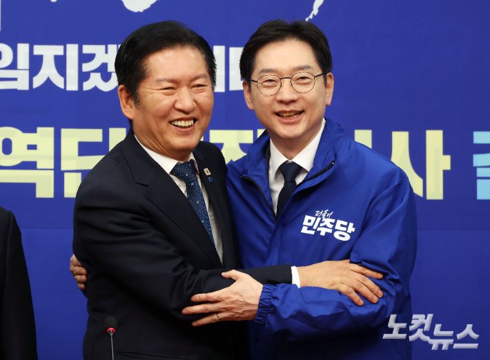 더불어민주당 정청래 대표가 5일 국회에서 열린 중앙당공천관리위원회 공천 심사 발표에서 경남도지사 후보로 확정된 김경수 지방시대위원장에게 선거복을 입혀준 뒤 포옹하고 있다. 황진환 기자