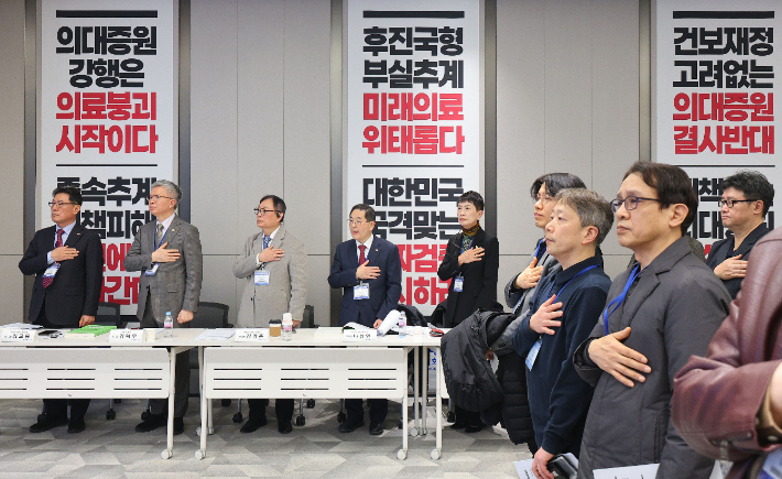 김택우 대한의사협회장(왼쪽 두번째)과 김교웅 대한의사협회 대의원회 의장(왼쪽 첫번째)을 비롯한 참석자들이 지난달 28일 서울 용산구 대한의사협회 회관에서 열린 임시대의원총회에서 국민의례를 하고 있다. 연합뉴스