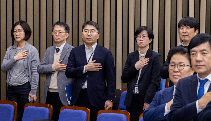 국무총리실 산하 검찰개혁추진단 관계자들이 국기에 경례하고 있다. 연합뉴스