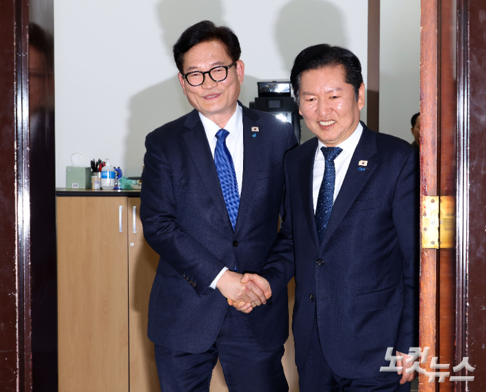 더불어민주당 정청래 대표(오른쪽)와 복당한 송영길 전 대표가 5일 국회 당대표실에서 면담 후 악수하고 있다. 황진환 기자