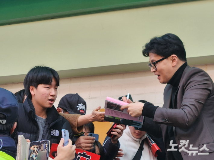 7일 오후 부산 금정구 부산대역 앞에서 한동훈 국민의힘 전 대표가 학생들에게 사인을 해주고 있다. 정혜린 기자
