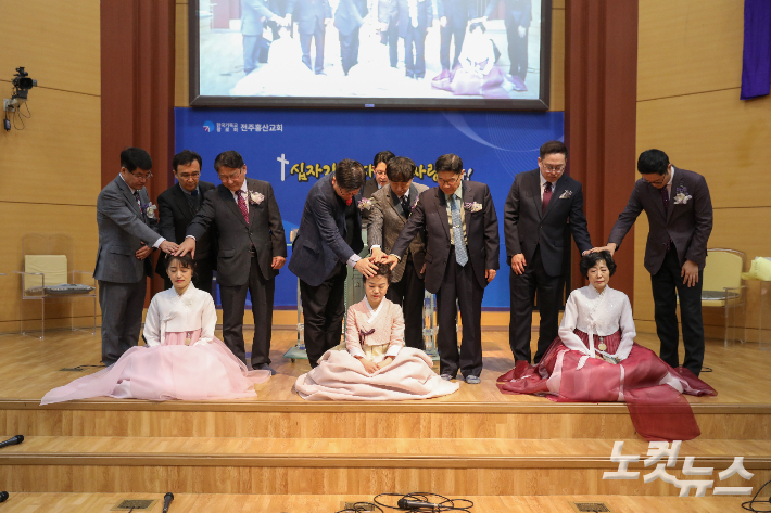 권사 임직식에서 진영현·노진희·박다남 권사가 안수기도를 받고 있다. 최화랑 기자