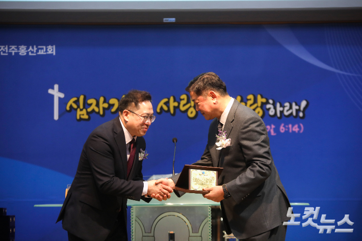 전주홍산교회 소진철 담임목사가 주찬규 목사에게 원로목사 추대패를 전달하고 있다. 최화랑 기자