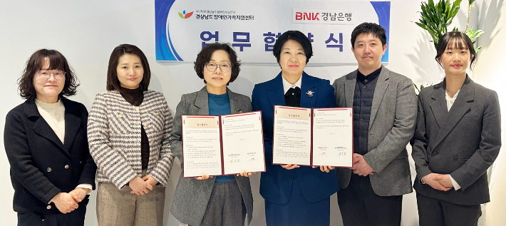 BNK경남은행 김경옥 상무(사진 오른쪽 세번째)와 경상남도장애인가족지원센터 서은경 센터장 등이 '금융교육 지원 업무협약'을 체결한 뒤 단체 기념촬영을 하고 있다. BNK경남은행 제공 