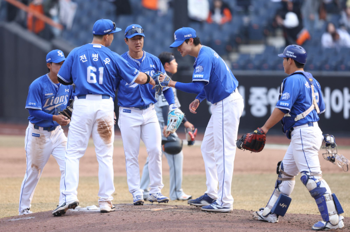 삼성 선수들이 12일 한화와 원정 시범 경기 개막전에서 승리한 뒤 서로 격려하고 있다. 삼성 