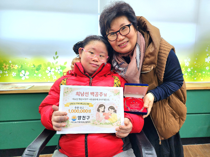 지난 12일 최남선(65)·백공주(35)씨가 서울 양천구 신정3동 주민센터에 성금을 기부한 뒤 기념 촬영을 하고 있다. 양천구청 제공