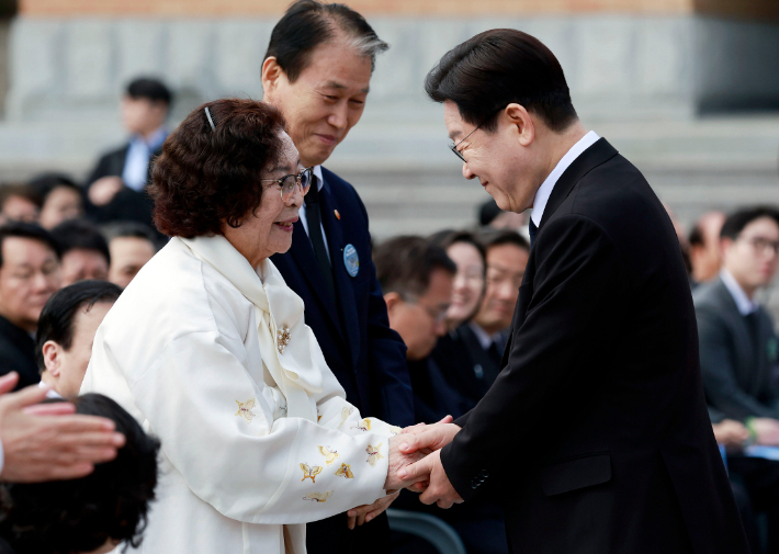 이재명 대통령이 15일 경남 창원시 마산회원구 국립 3·15 민주 묘지에서 열린 제66주년 3·15의거 기념식에서 기념사를 마친 뒤 오무선 유족회장의 손을 잡고 있다. 연합뉴스