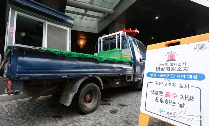 수도권과 충남 지역에 미세먼지 비상저감조치가 시행된 17일 서울 중구 서울시청 주차장 입구에 행정·공공기관 차량 대상 2부제 실시 안내문이 설치되어 있다.