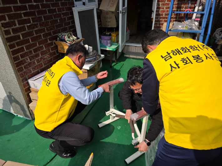 남해화학 사회봉사단이 안전 손잡이를 설치하고 있다. 남해화학 제공