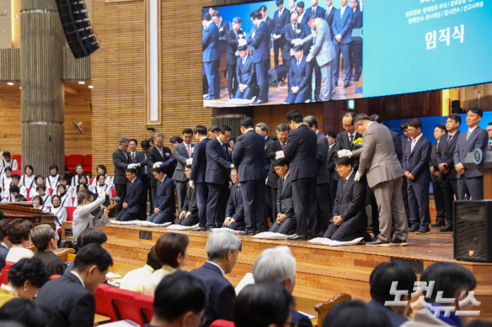 임직자들이 안수위원들의 기도를 받고 있다. 최화랑 기자