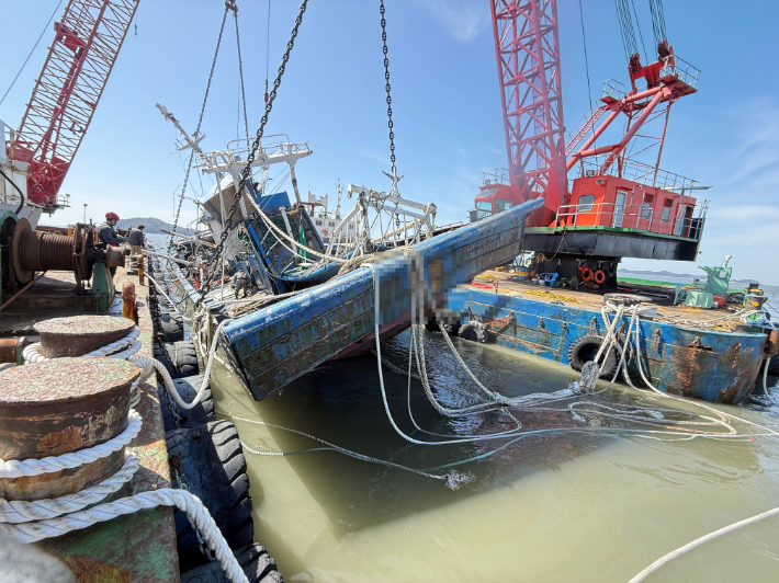 해상크레인선 2척에 의해 인양되고 있는 침몰 선박 A호. 보령해경 제공