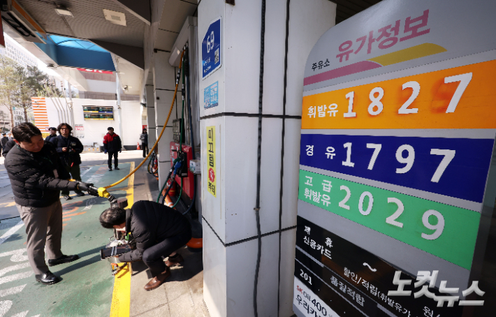 석유 최고가격제 시행 첫날인 13일 서울 마포구 한 주유소에서 한국석유관리원 관계자들이 정량기준탱크를 통해 휘발유 정량 확인을 하고 있다. 황진환 기자