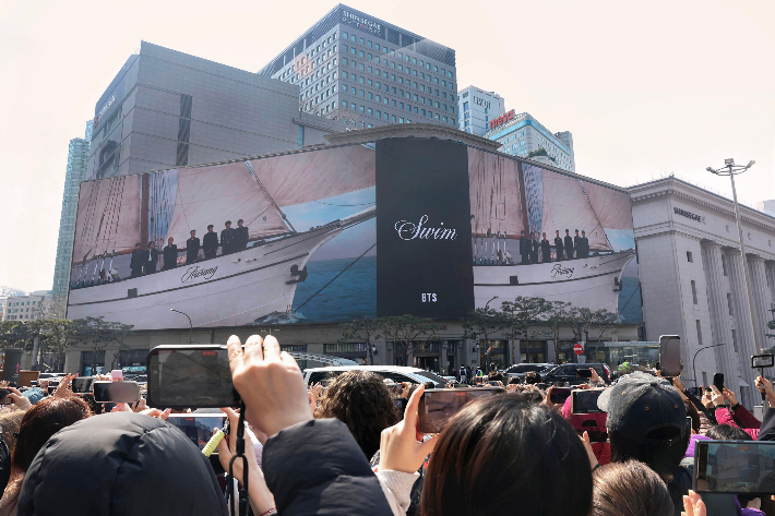 신세계백화점은 20일 BTS 새 앨범 발매에 맞춰 신곡의 뮤직비디오를 명동 본점 외벽 대형 전광판에서 송출하며 행사 분위기를 끌어올렸다. 신세계백화점 제공 