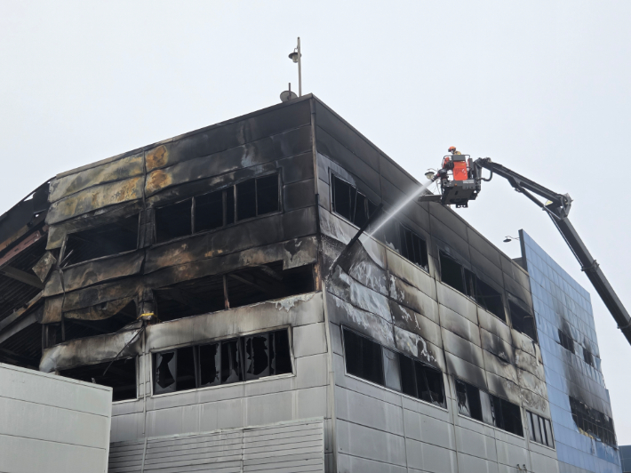 21일 오전 소방당국이 건물 외부에서 물을 뿌리며 잔불 정리를 하고 있다. 박우경 기자