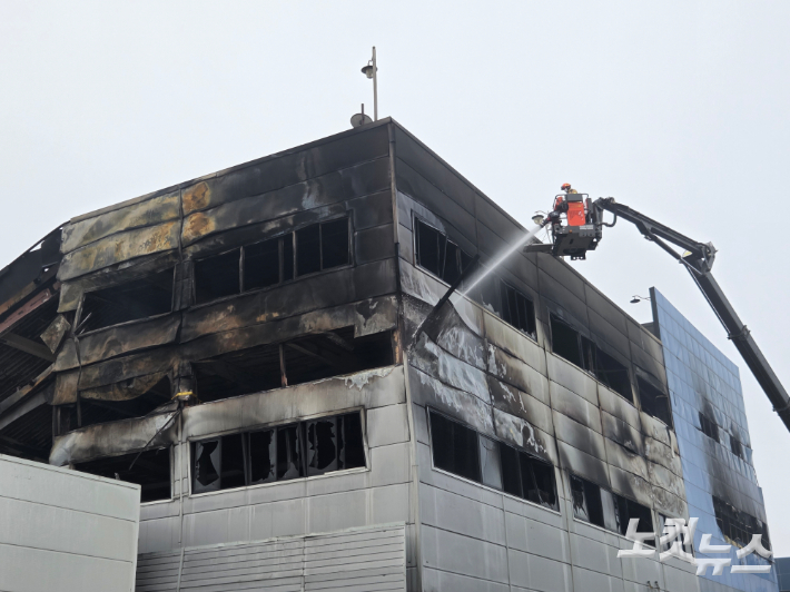 21일 오전 소방당국이 건물 외부에서 물을 뿌리며 잔불 정리를 하고 있다. 박우경 기자