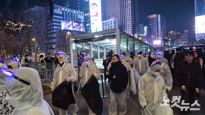 BTS 팬 아미들이 공연이 끝난 뒤 쓰레기 봉투를 손에 들고 거리 환경 미화에 나선 모습. 김지은 기자