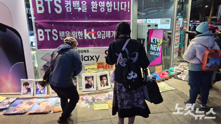귀가 중 아쉬운 듯 BTS 굿즈를 촬영하는 아미들. 김지은 기자