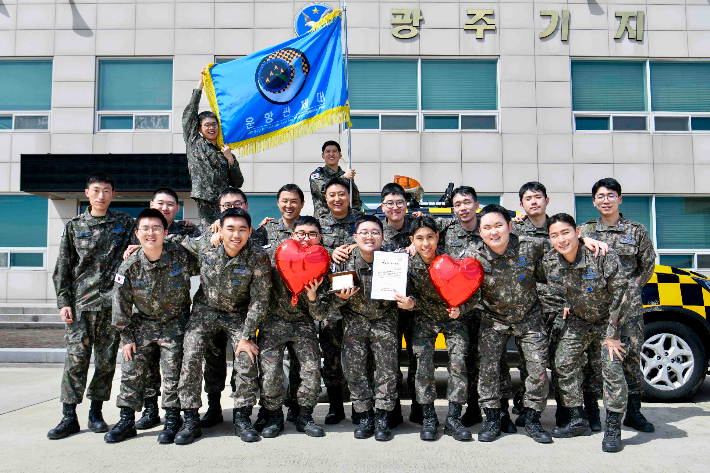 공군 제1전투비행단 운항관제대 장병들이 조혈모세포 기증을 마친 송민준 일병(앞줄 가운데)을 축하하며 기념촬영을 하고 있다. 공군 제1전투비행단 제공
