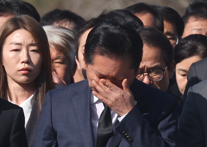 더불어민주당 정청래 대표가 23일 오전 경남 김해시 진영읍 봉하마을 노무현 전 대통령 묘역을 참배하며 눈물을 흘리고 있다. 연합뉴스