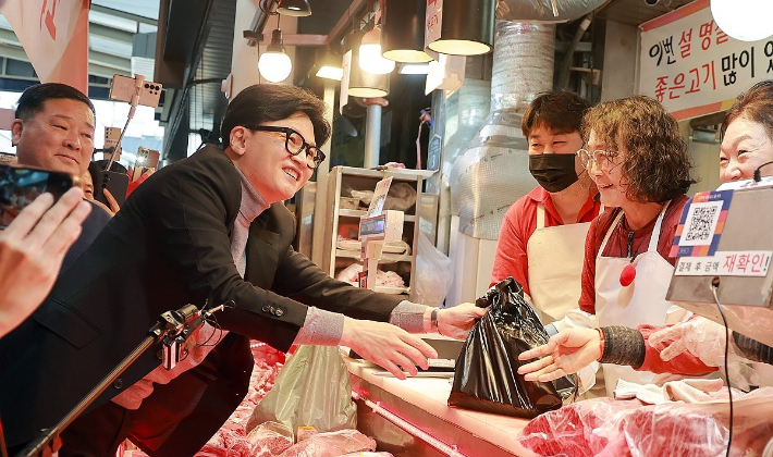 국민의힘 한동훈 전 대표가 22일 서울 동대문구 경동시장을 방문해 고기를 구매하고 있다. 연합뉴스