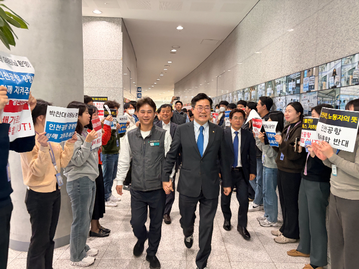 박찬대 국회의원이 인천공항 노조 측과 손을 맞잡고 걸어가고 있다. 박 의원 측 제공