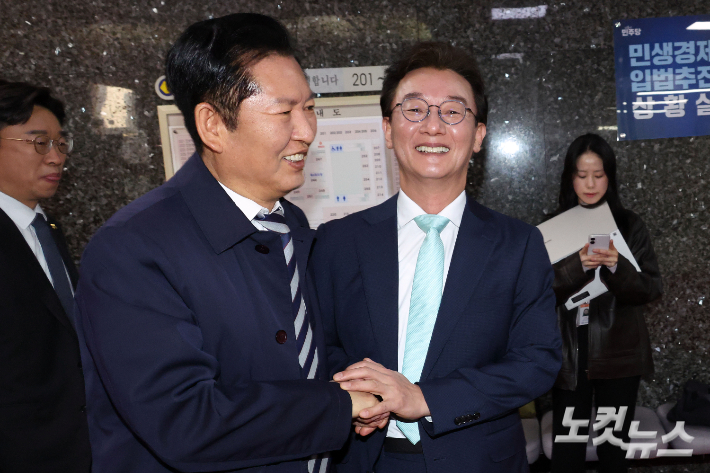 더불어민주당 정청래 대표가 24일 서울 여의도 국회에서 부산 글로벌허브도시 조성에 관한 특별법안 관련 간담회에 참석하던 전재수 의원과 만나 손을 잡고 있다. 윤창원 기자