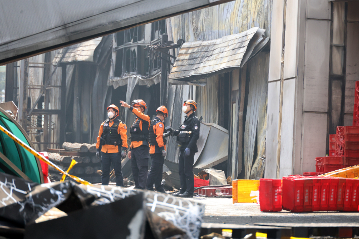 소방 당국 관계자들이 불에 탄 건물 안에서 내부를 살피고 있다. 연합뉴스