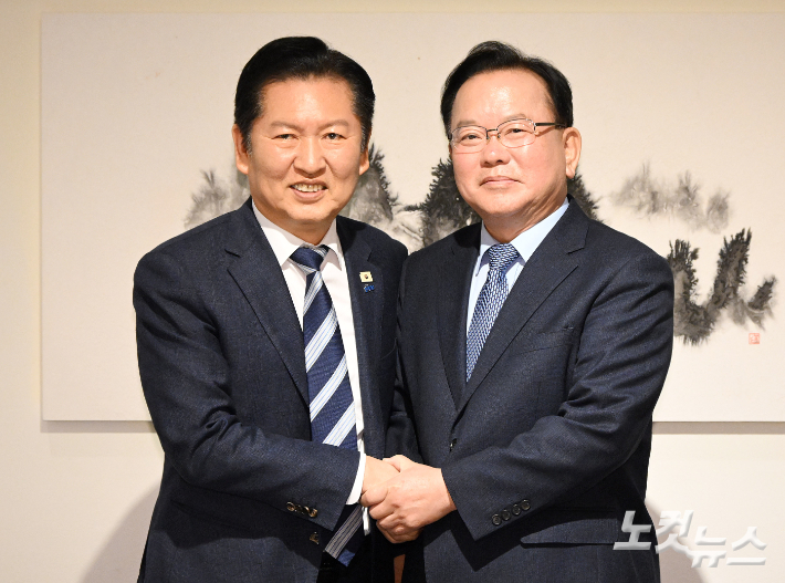 정청래 더불어민주당 대표와 김부겸 전 국무총리가 26일 서울 중구 달개비에서 회동 전 손을 맞잡고 있다. 국회사진기자단