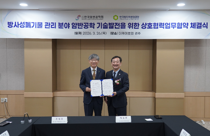 한국원자력환경공단 조성돈(왼쪽) 이사장과 암반공학회 이승원 학회장이 상호협력업무협약을 체결한 뒤 기념촬영을 하고 있다. 공단 제공