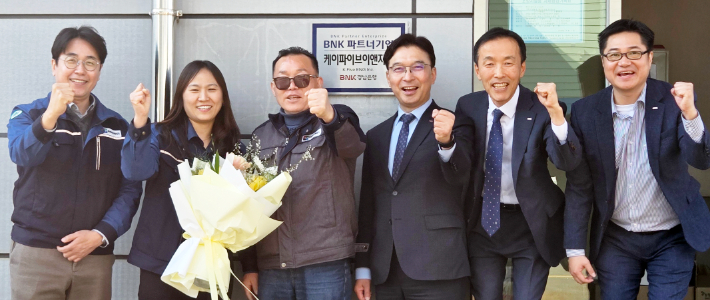 BNK경남은행 임재문 부행장(사진 오른쪽 세번째)과 케이파이브이앤지㈜ 김장호 대표 등이 BNK 파트너기업 현판식을 가진 뒤 기념촬영을 하고 있다. BNK경남은행 제공 