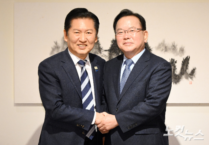 정청래 더불어민주당 대표와 김부겸 전 국무총리가 26일 서울 중구 달개비에서 회동 전 손을 맞잡고 있다. 국회사진기자단