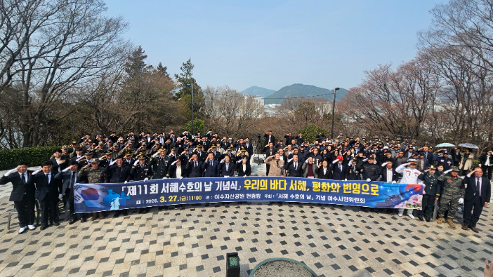 참석자들이 27일 여수 자산호국공원 현충탑에서 열린 제11회 서해수호의 날 기념식에서 국기에 대한 경례를 하고 있다. 서해수호의날 기념 여수시민위 제공