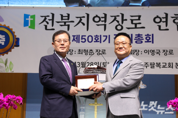 신임 회장 이영국 장로가 직전 회장 최형춘 장로에게 감사패를 전달하고 있다. 최화랑 기자
